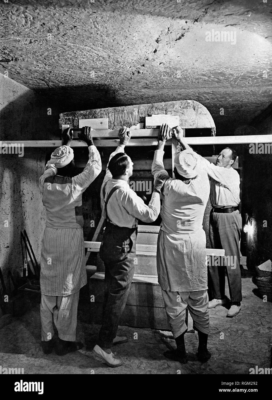 Howard Carter (second left) who discovered Tutankhamun's Tomb in the Valley of the Kings, Luxor, Egypt. November 1922 with two Egyptian workers and Arthur Callender working inside the tomb. Scanned from image material in the archives of Press Portrait Service - (formerly Press Portrait Bureau). Stock Photo