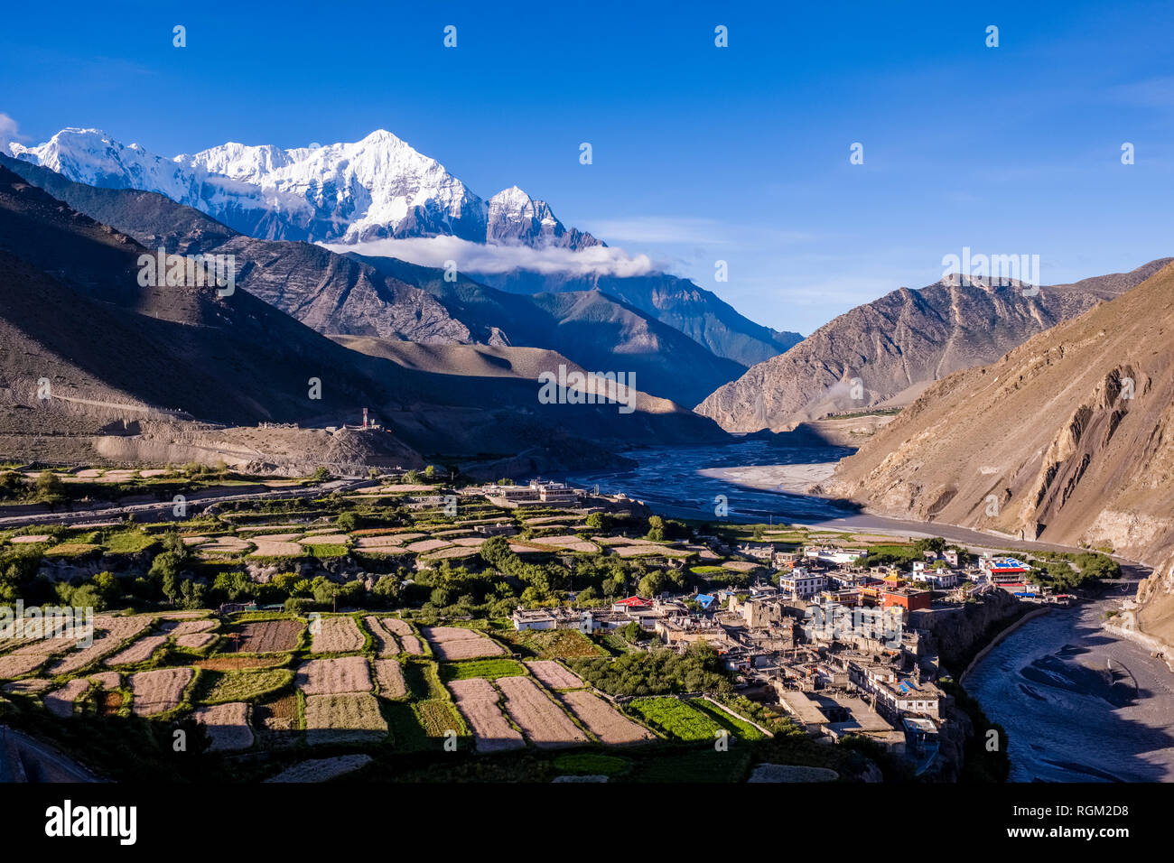 Aerial view on the town and agricultural surroundings in Kali Gandaki valley, the summit of the mountain Nilgiri in the distance Stock Photo