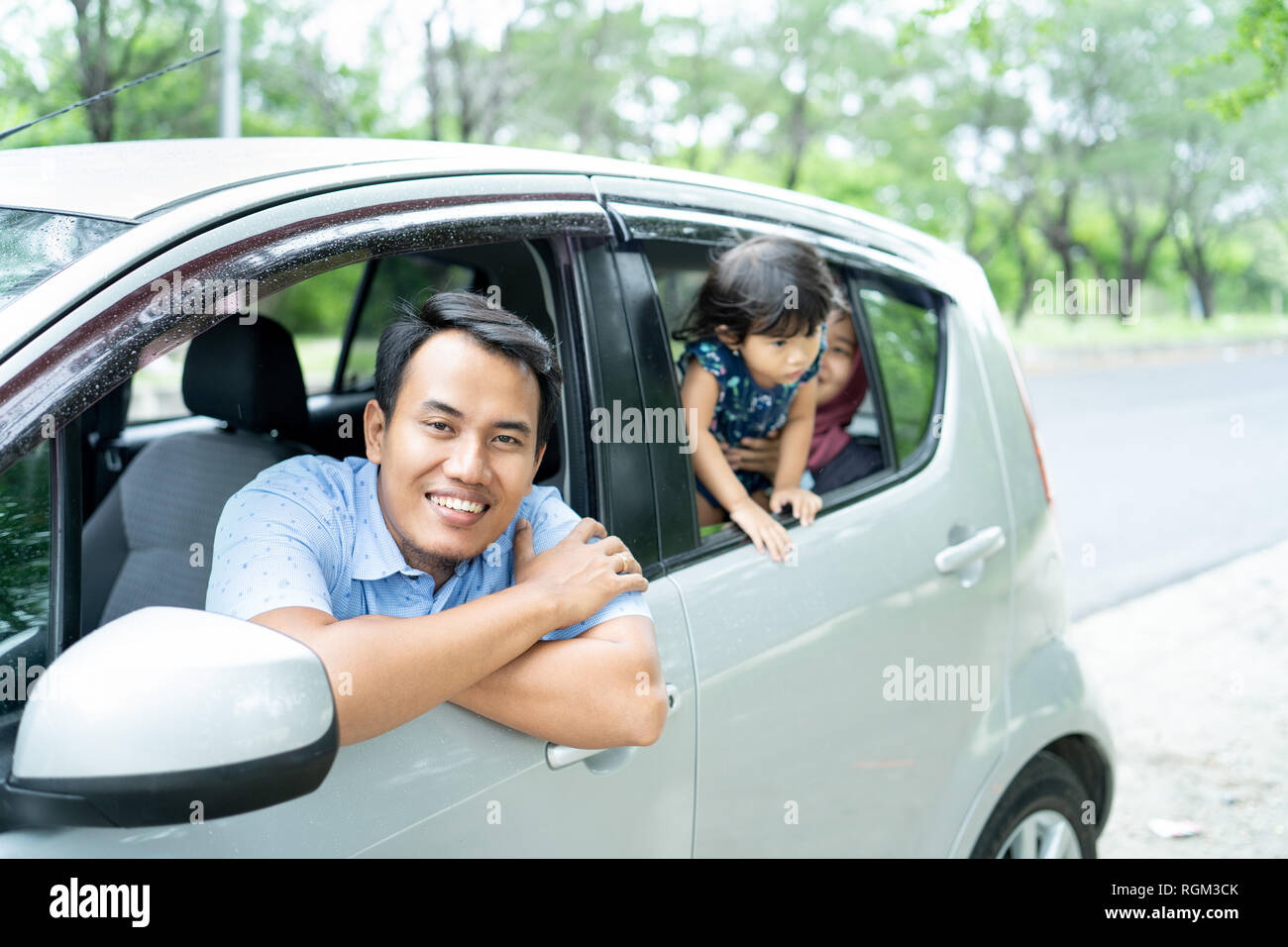portrait father crossed hands on car window when look at camera Stock