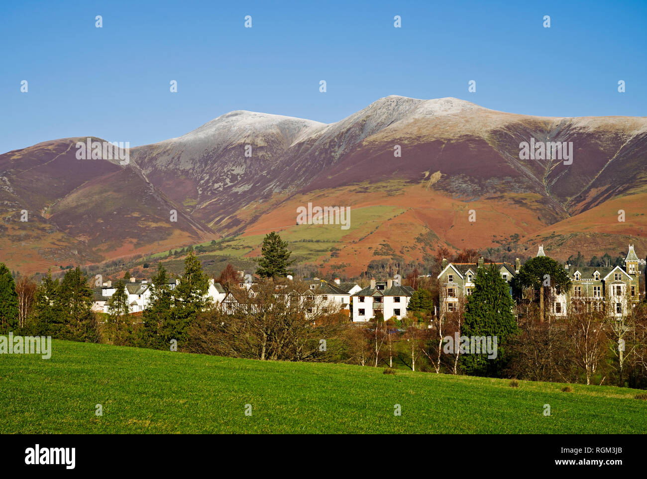 View over Keswick to the summit of snow-capped Skiddaw on a bright sunny winter's day, Lake District, Cumbria, England UK. Stock Photo
