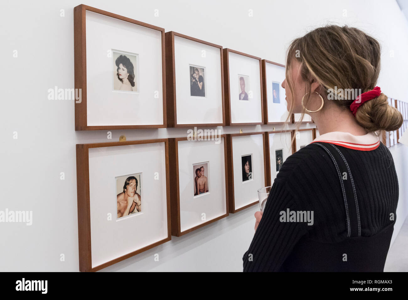 London, UK.  30 January 2019. A visitor views works on display, including 'Jane Fonda' (1982) (top left) and 'Arnold Schwarzenegger' (1977) (bottom left). Preview of 'Andy Warhol Polaroid Pictures', an exhibition of over 60 portrait and self-portrait Polaroid photographs by Andy Warhol.  The works, which depict artists, actors, politicians and friends of his Factory entourage in New York during the 1970s and 80s, are on display 2 February to 13 April 2019 at Bastian Gallery in Mayfair.  Credit: Stephen Chung / Alamy Live News Stock Photo