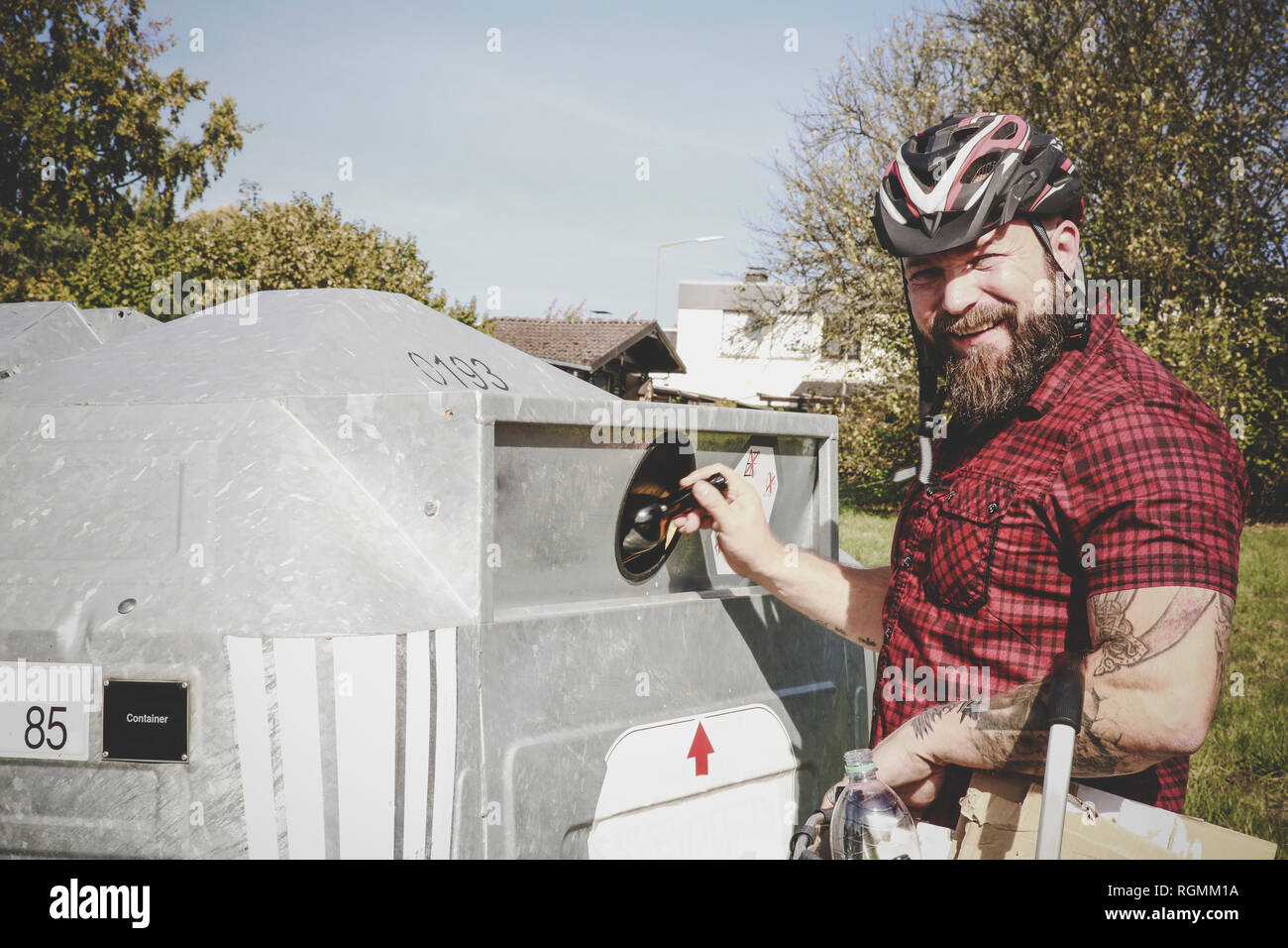 Portrait of man recycling glass bottle in bottle bank Stock Photo Alamy