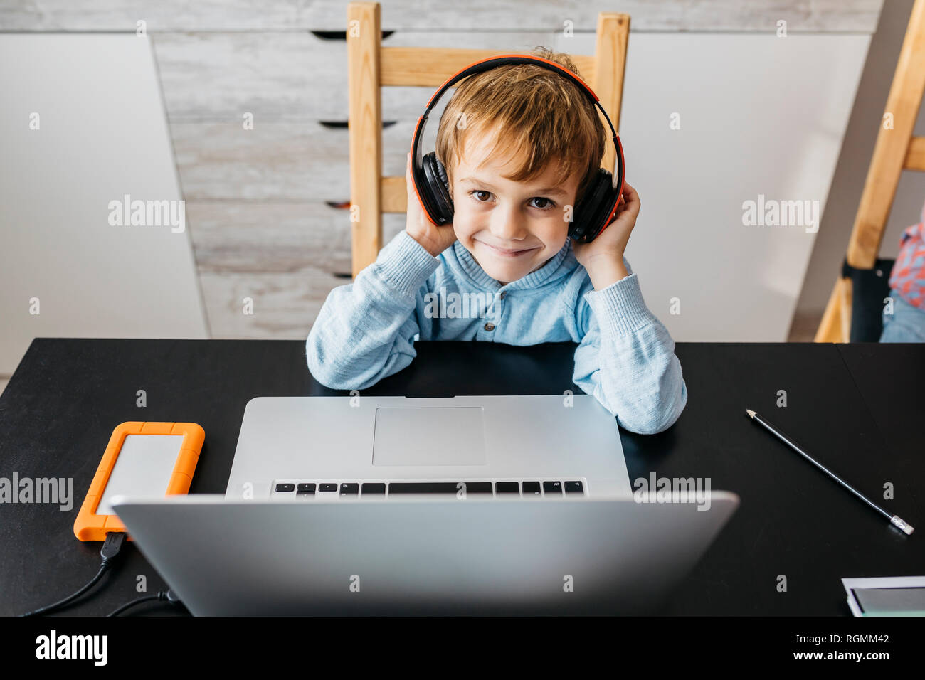 Little boy sitting table haedphones hi-res stock photography and images ...