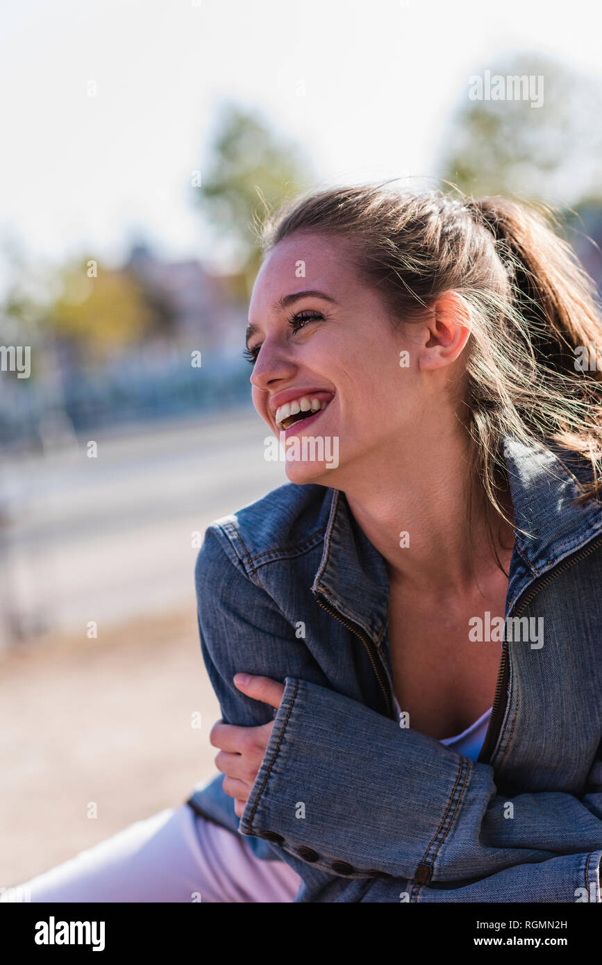 Portrait of laughing young woman outdoors Stock Photo