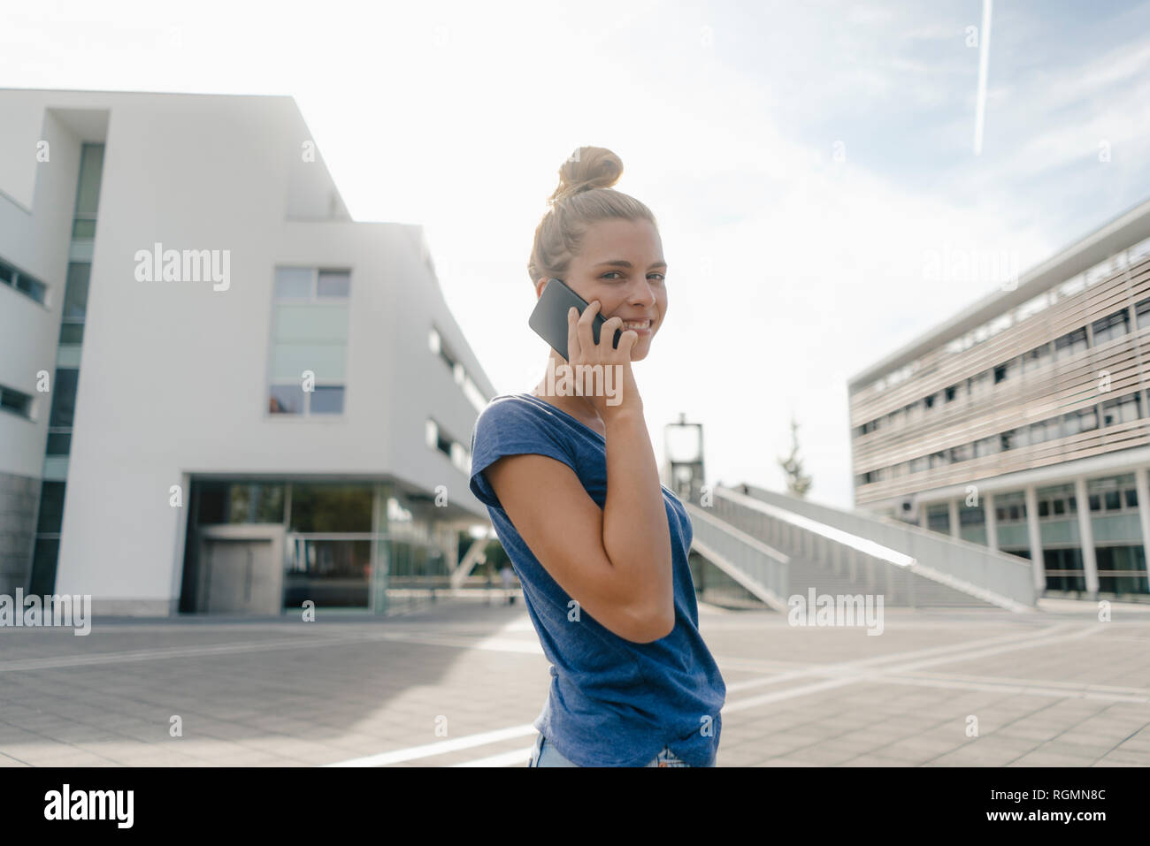 Netherlands, Maastricht, smiling young woman on cell phone in the city Stock Photo