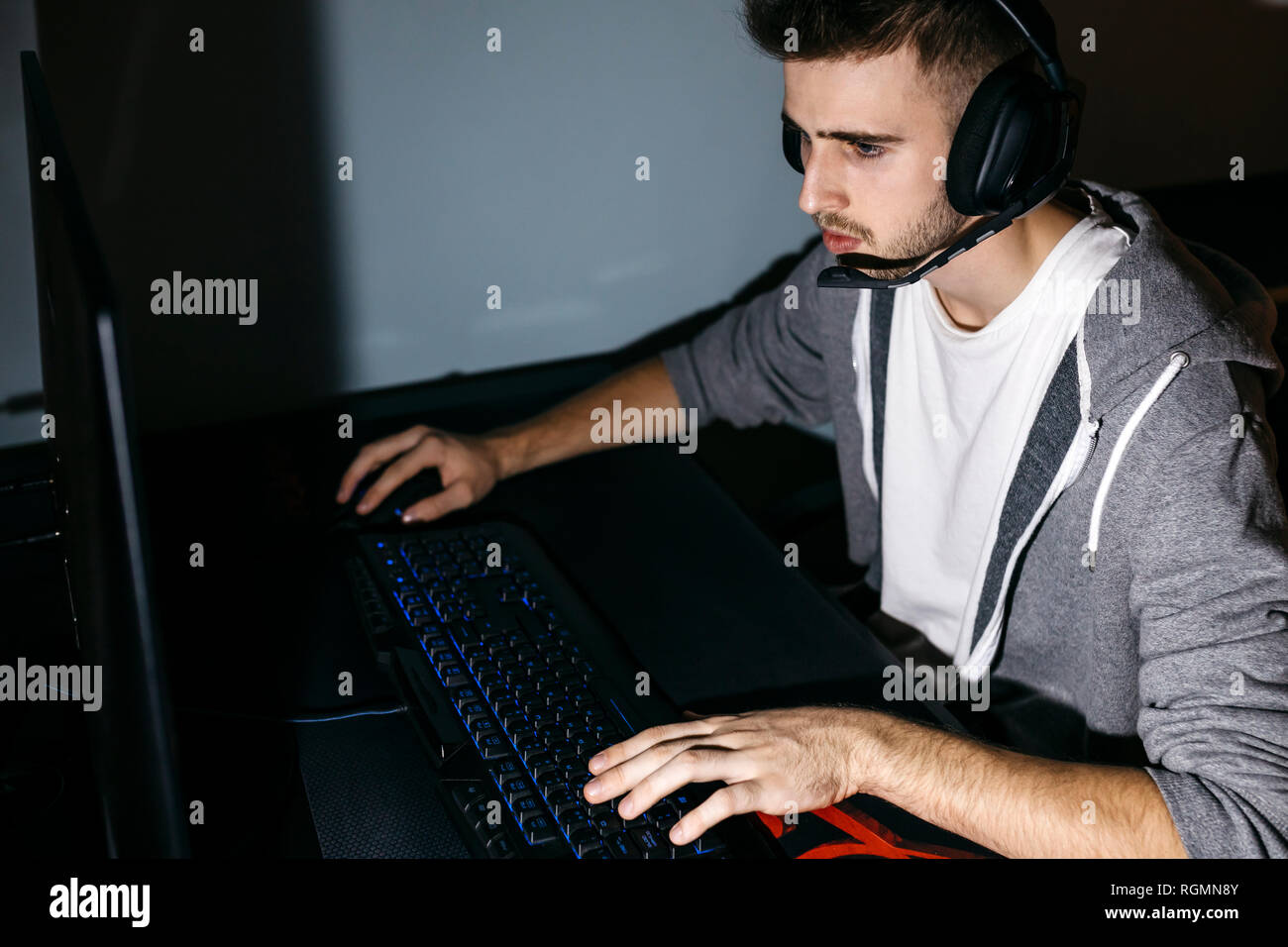 Young man sitting at his PC, playing computer games Stock Photo