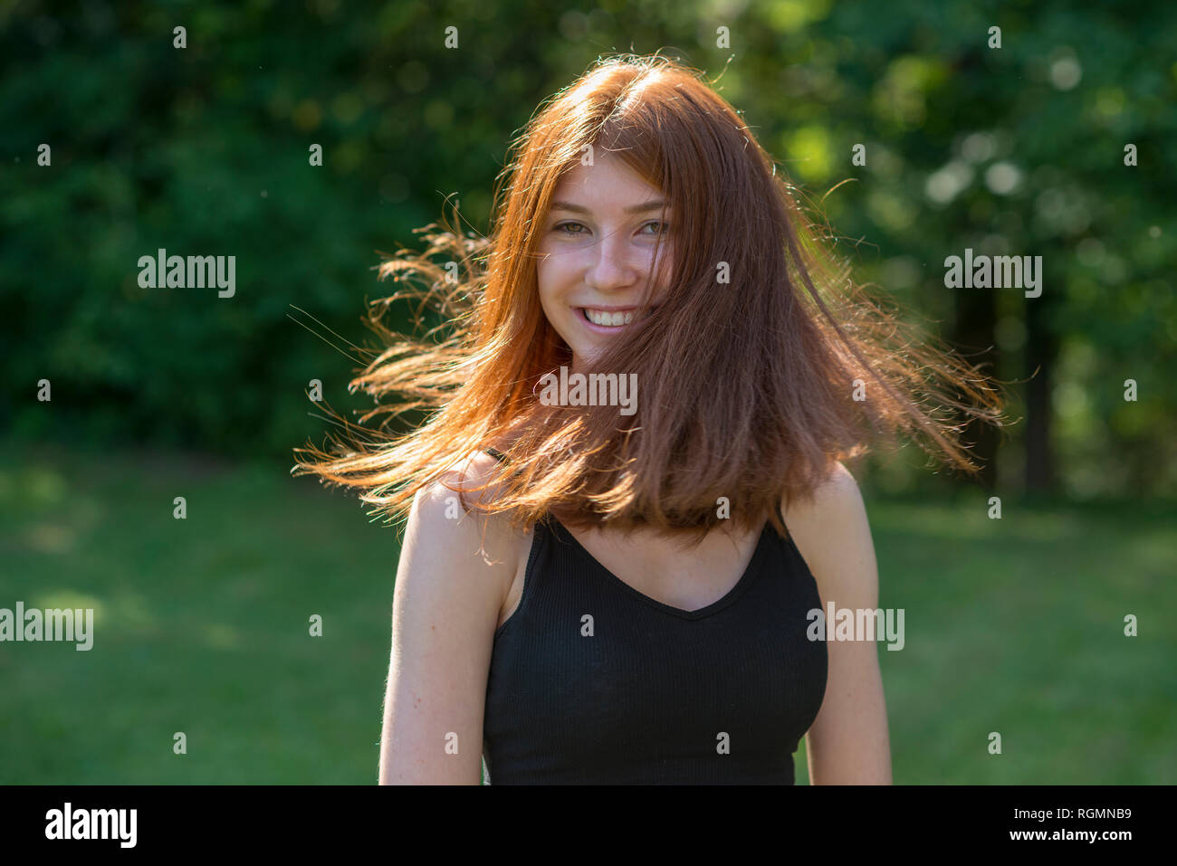 Portrait of redheaded teenage girl tossing her hair Stock Photo