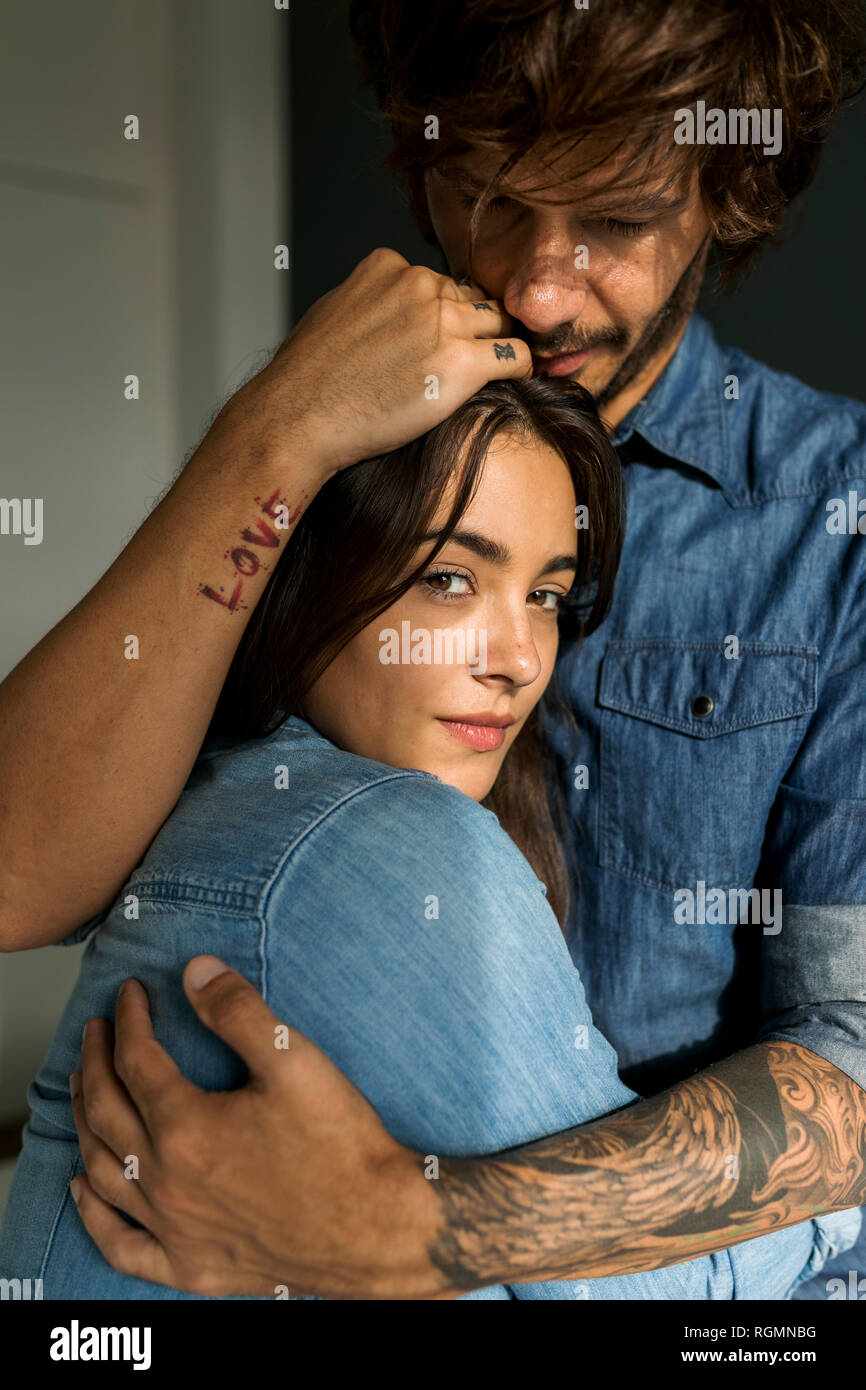 Tattooed man embracing girlfriend Stock Photo