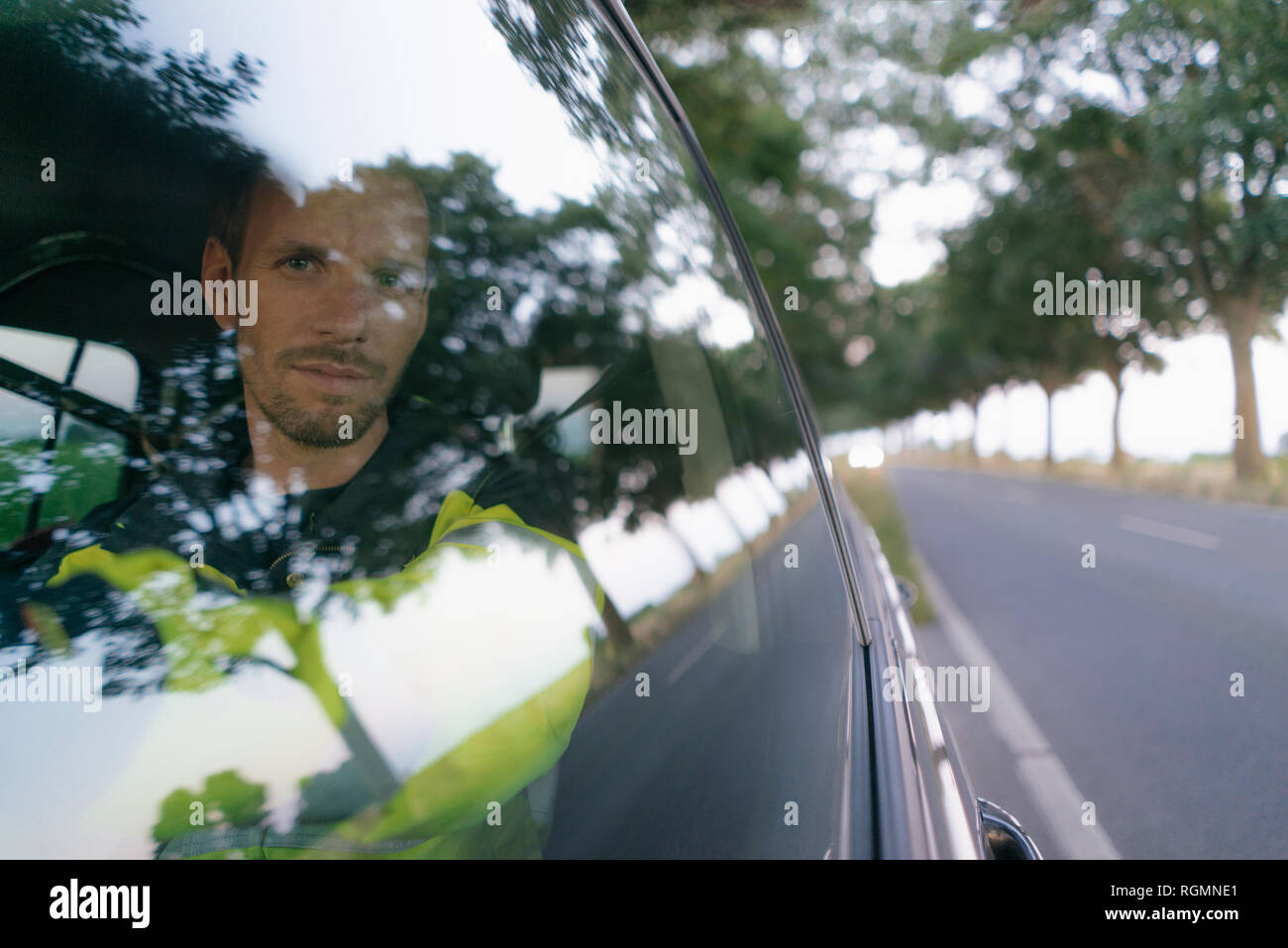 Portrait of man in protective workwear in a car at country road Stock Photo