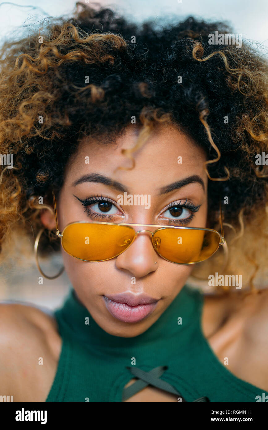 Portrait of cool young woman wearing yellow sunglasses Stock Photo