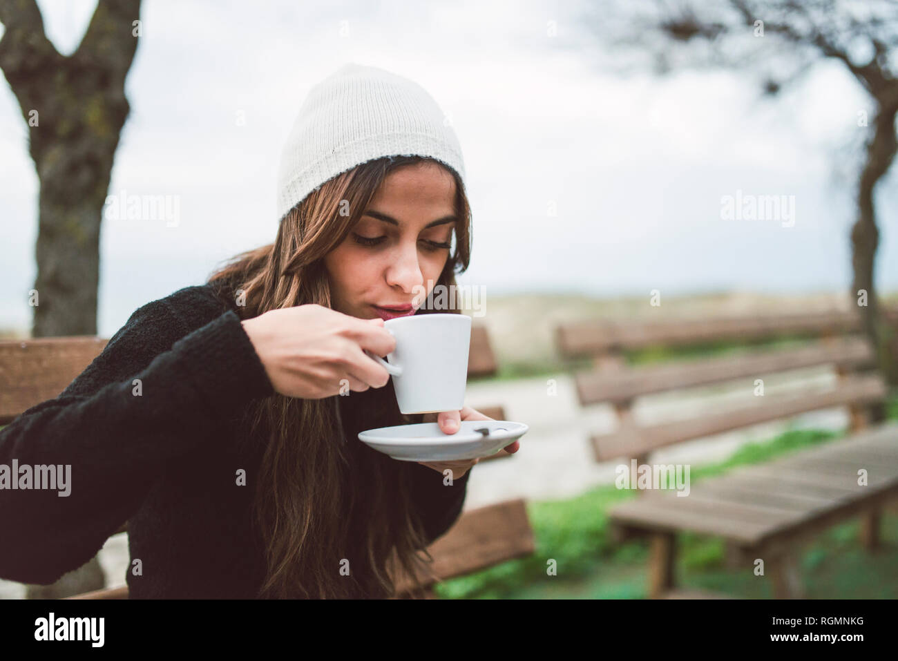 Portrait of young woman drinking cup of coffee outdoors Stock Photo