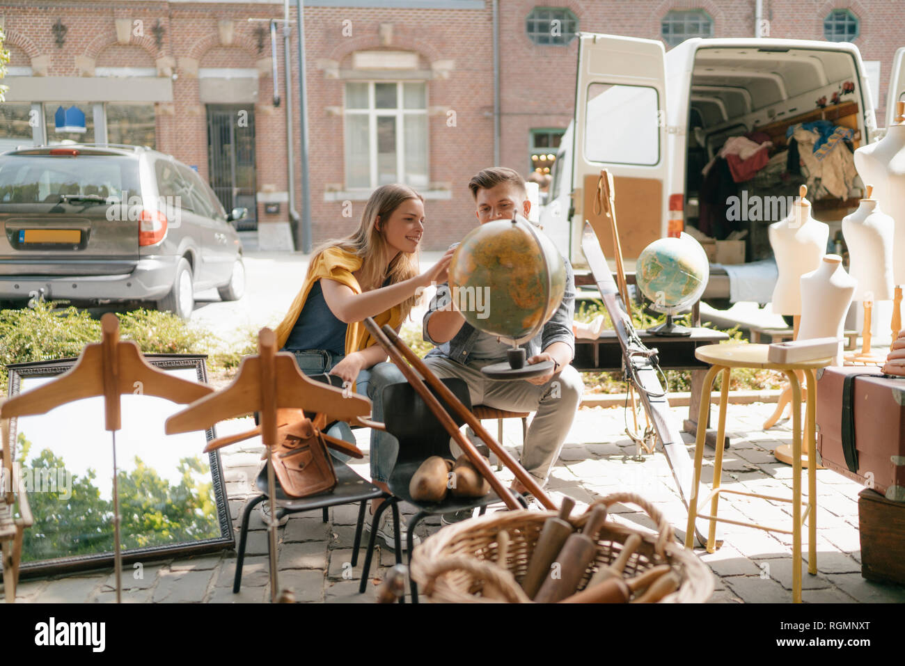 Belgium, Tongeren, young couple examining globe on an antique flea market Stock Photo