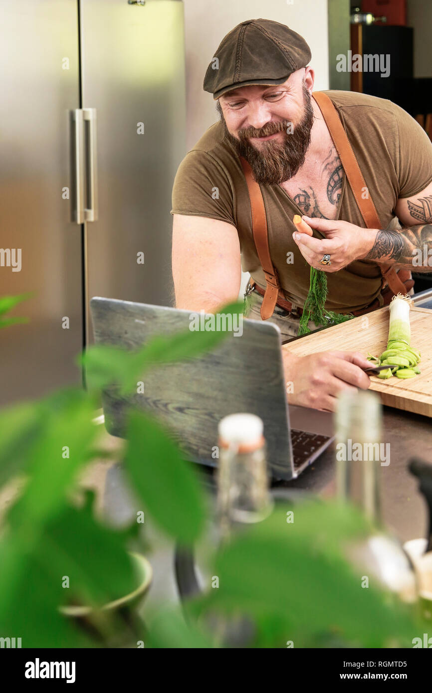 Mature man trying out vegetarian online-recipes Stock Photo