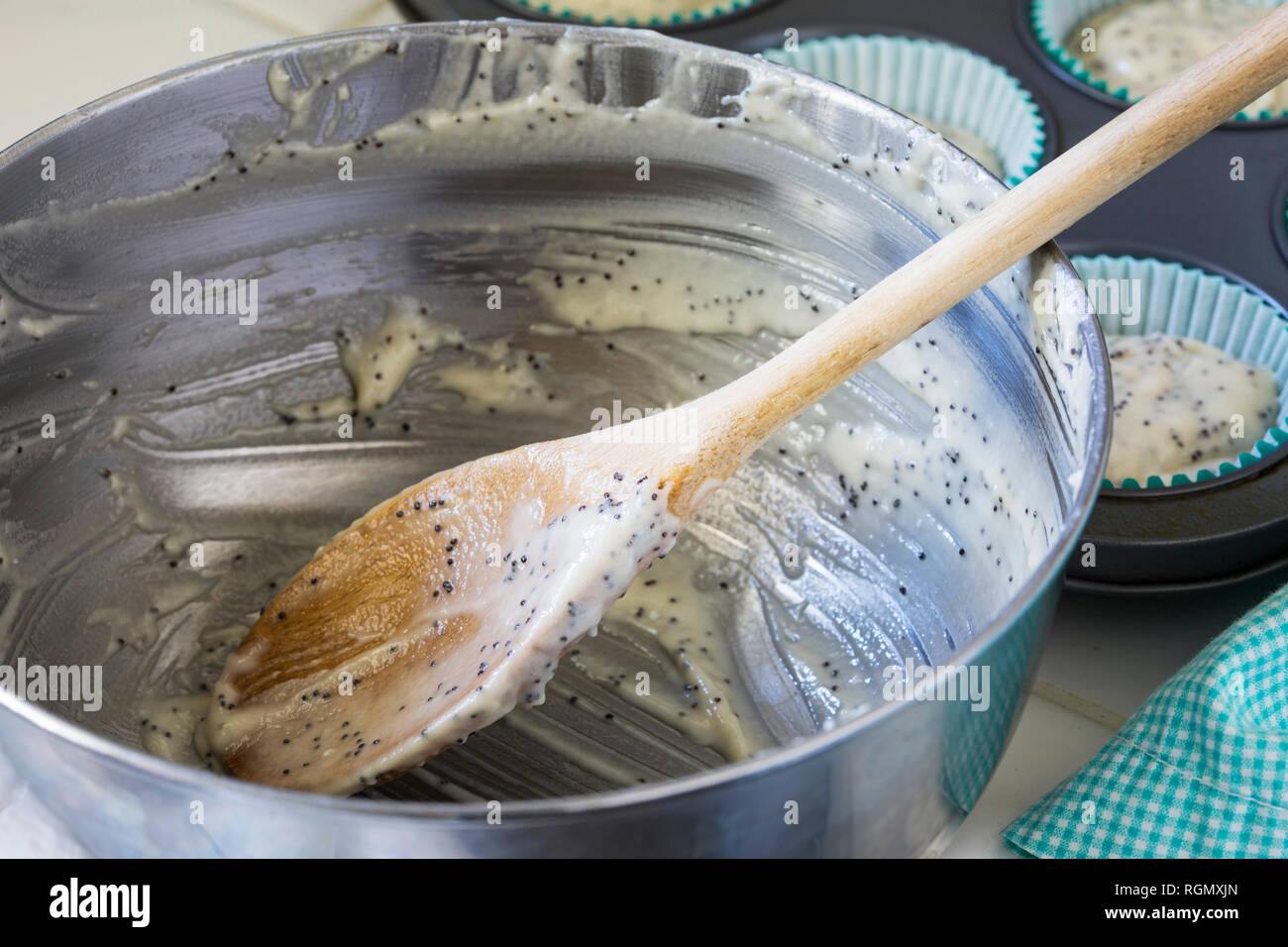 Metal mixing bowl with wooden spoon and batter from poppy seed muffins  Stock Photo - Alamy