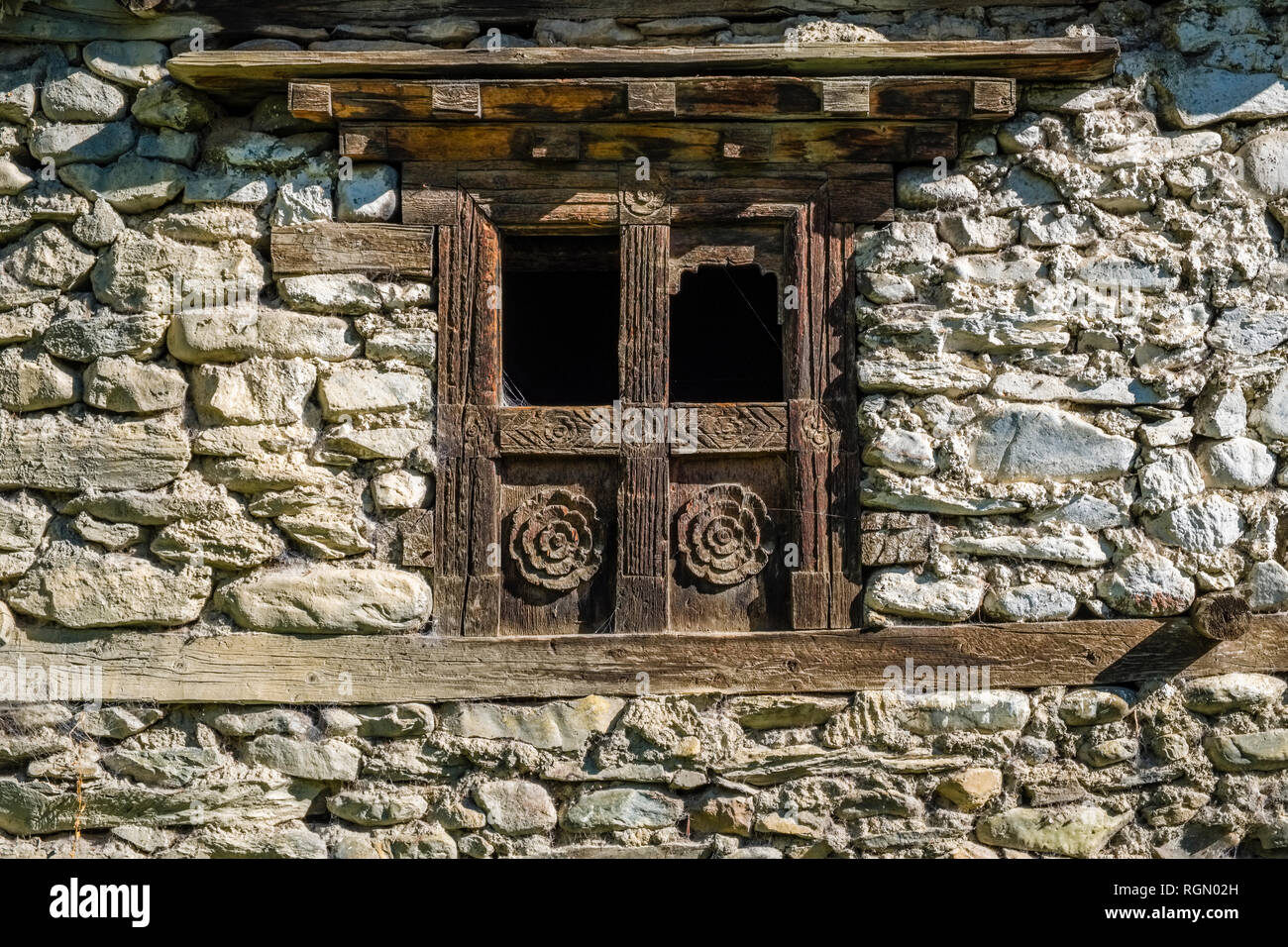 Facade of a local stone house with an artfully carved wooden window ...