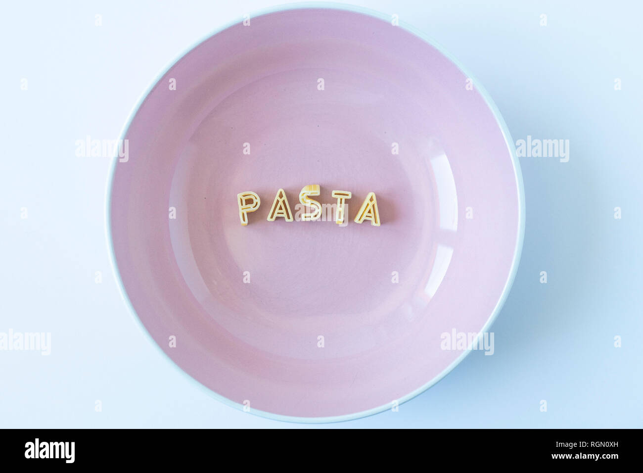 The word 'pasta' composed with real pasta letters in a pink dish. Top view. Stock Photo