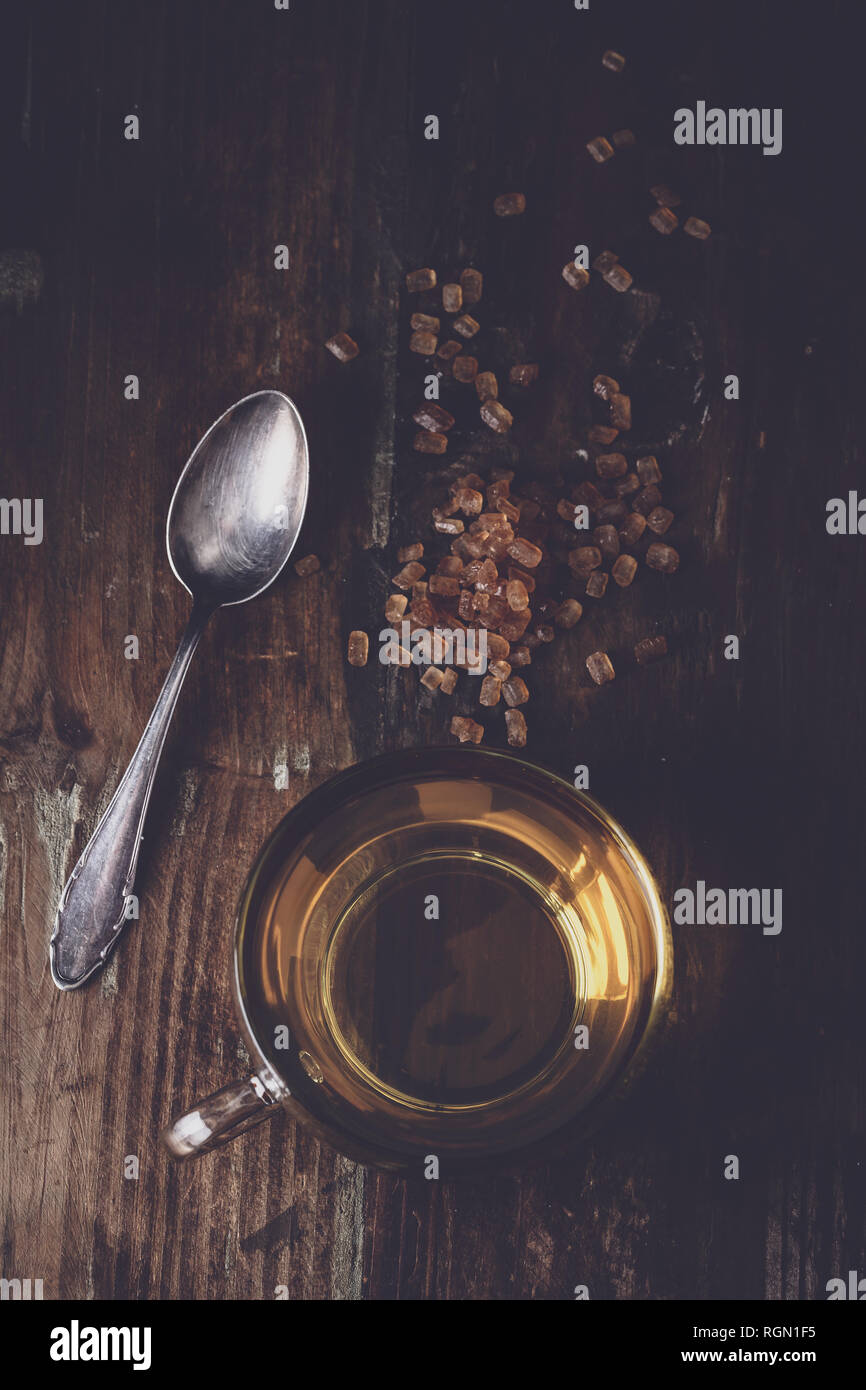 freshly poured tea with brown tea sugar on a wooden background Stock Photo