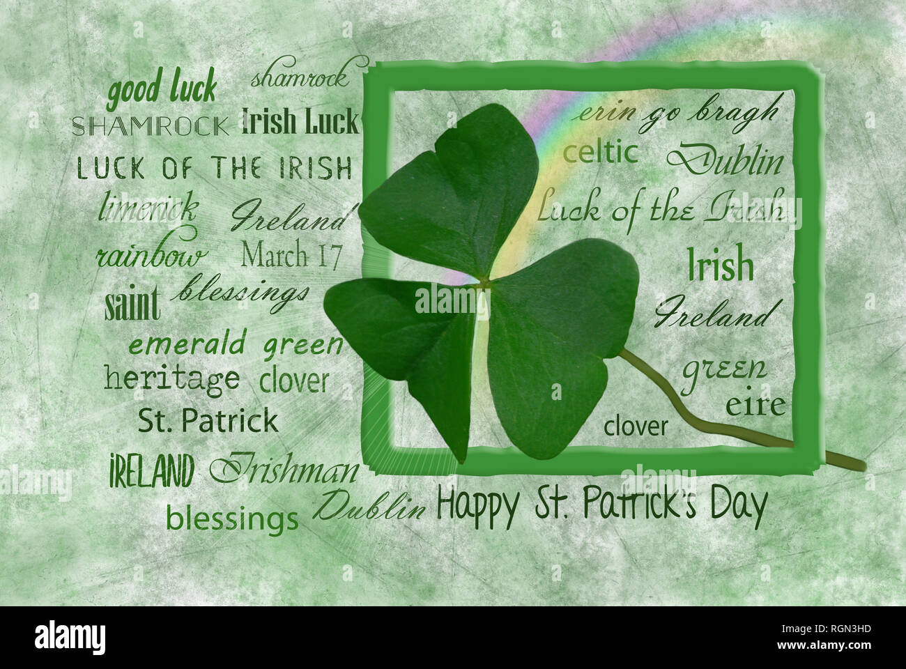 close up of rainbow and green Irish shamrock leaf in frame with St. Patrick Day holiday word cloud on textured background Stock Photo
