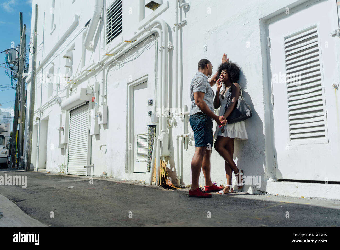 Smiling affectionate young couple standing at building Stock Photo