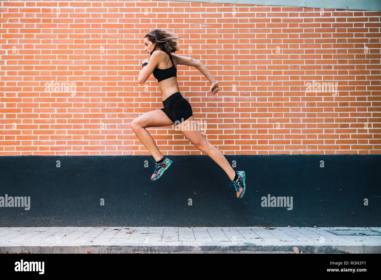 Fit young woman running an jumping in park Stock Photo