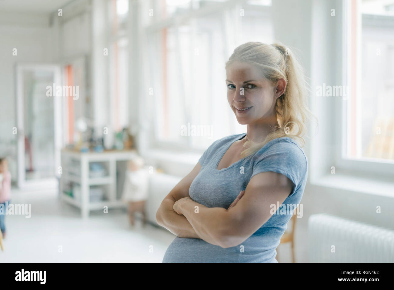 Portrait of smiling pregnant woman in a bright room Stock Photo
