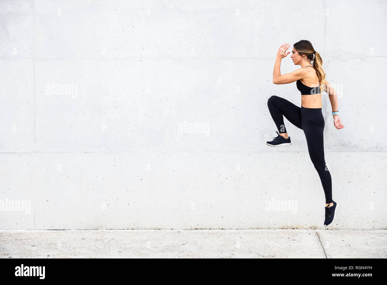 Athlete jumping in front of white wall Stock Photo
