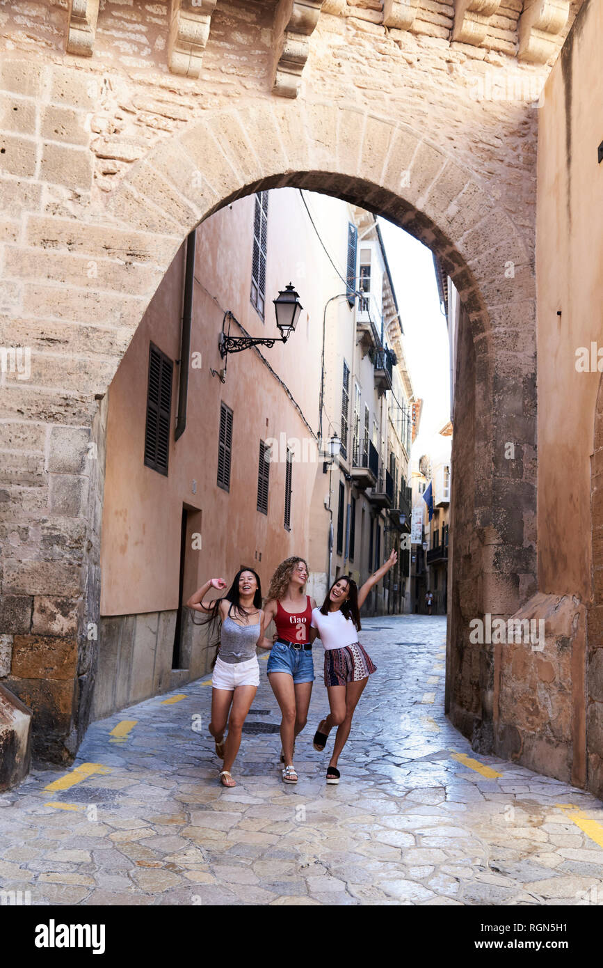 Spain, Mallorca, Palma, three happy young women exploring the city Stock Photo