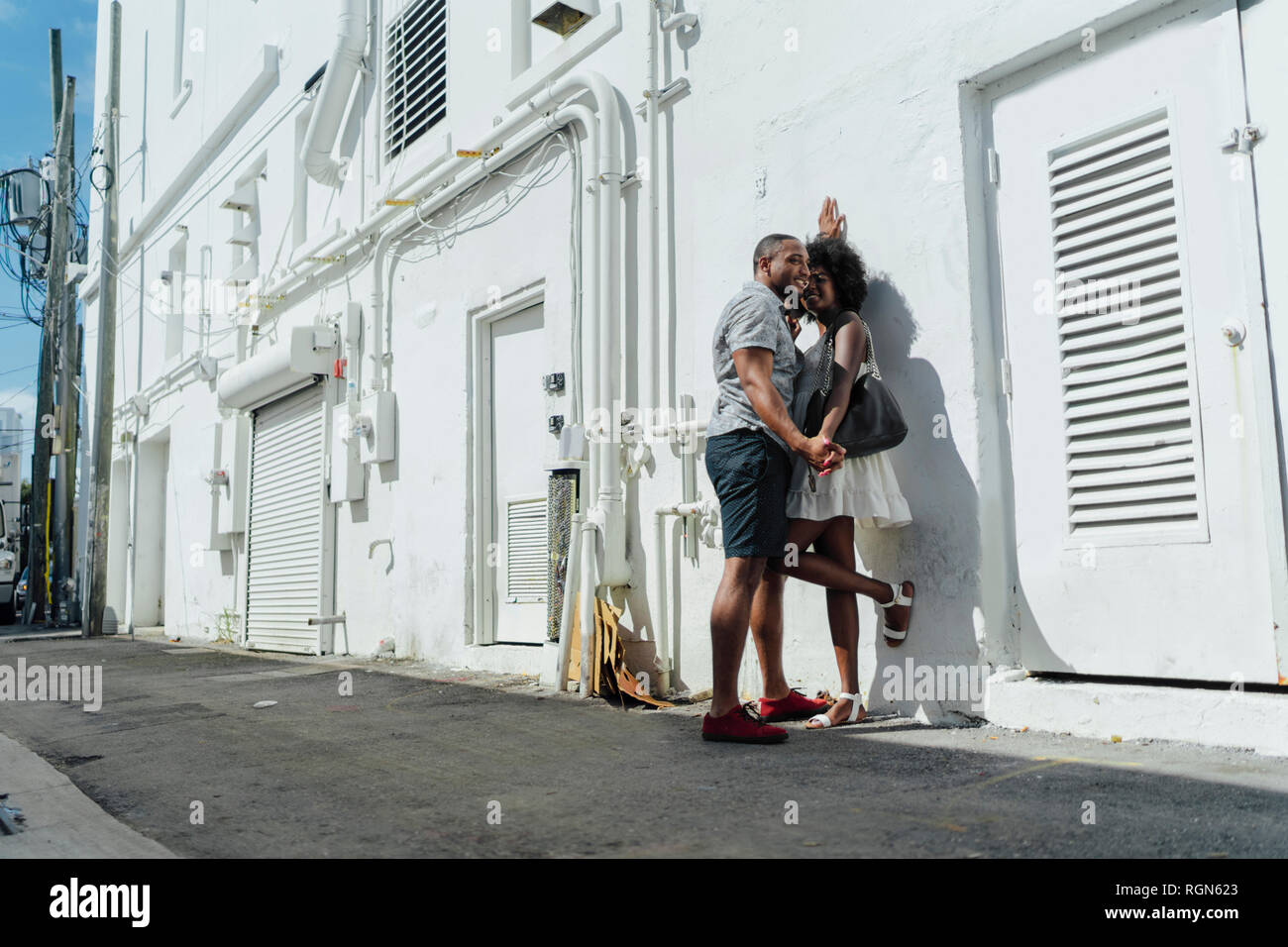 Smiling affectionate young couple standing at building Stock Photo