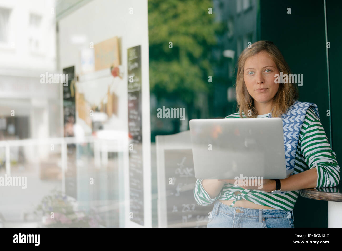 Portrait of young woman with laptop in a cafe Stock Photo - Alamy