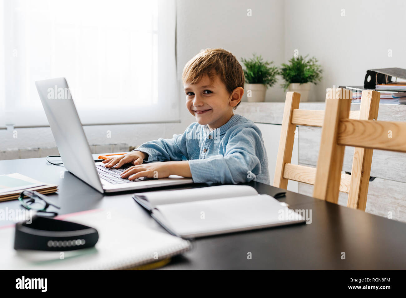 Little boy sitting in his father's office, using laptop Stock Photo - Alamy