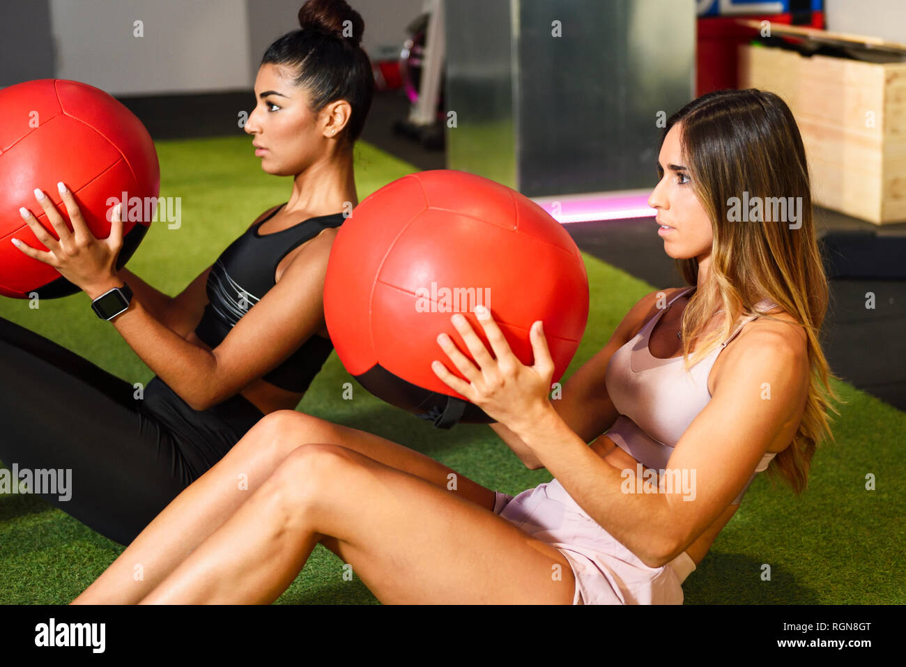 Young people doing ab training with fitness balls Stock Photo