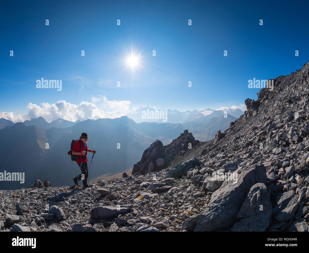 Border region Italy Switzerland, senior man hiking in mountain landscape at Piz Umbrail Stock Photo