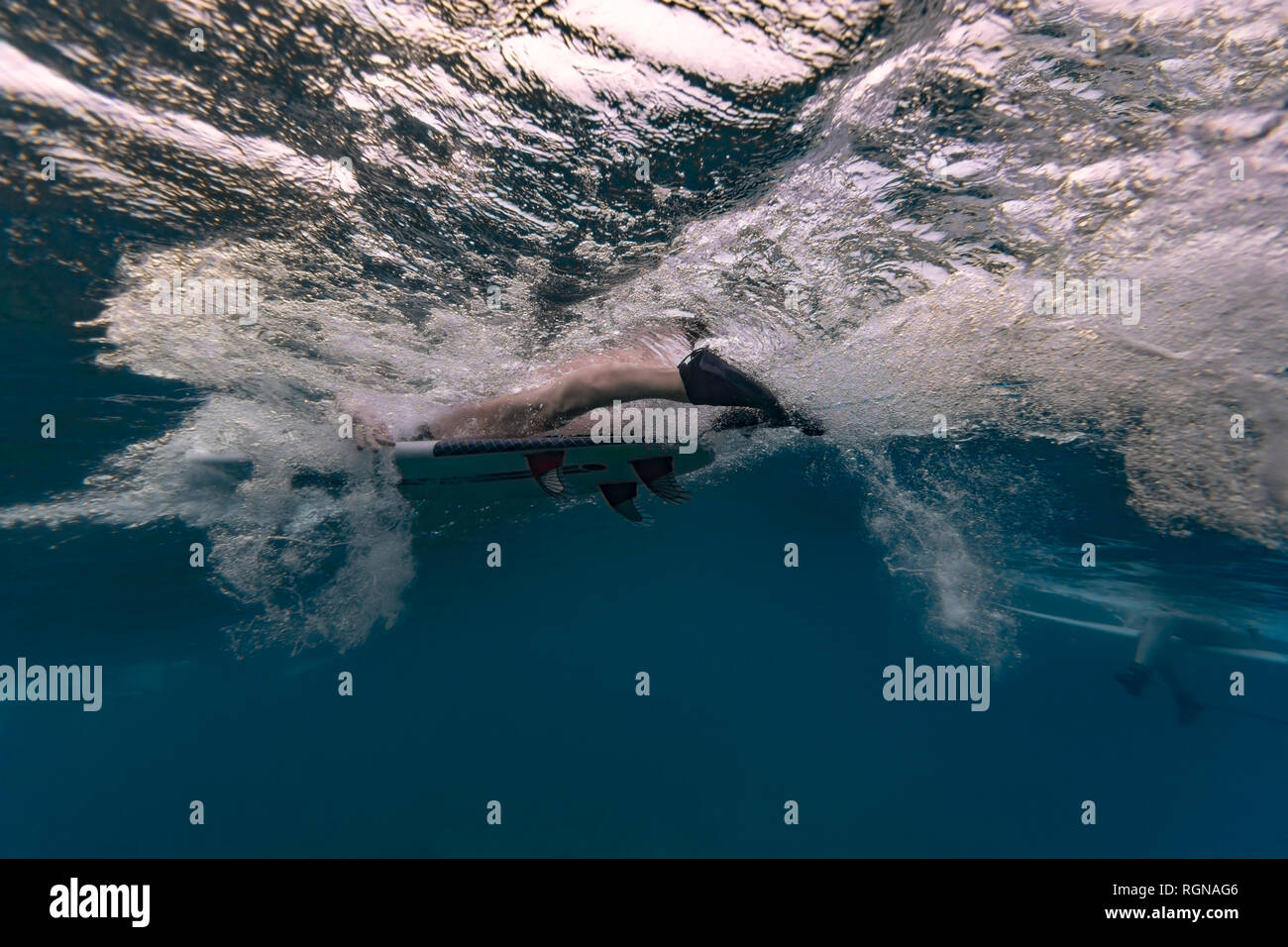 Under water surfers sitting surfboard hires stock photography and