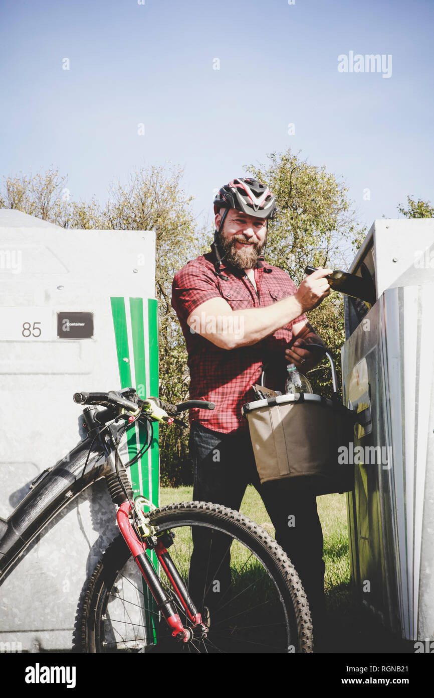 Portrait of man recycling glass bottle in bottle cyclist Stock Photo