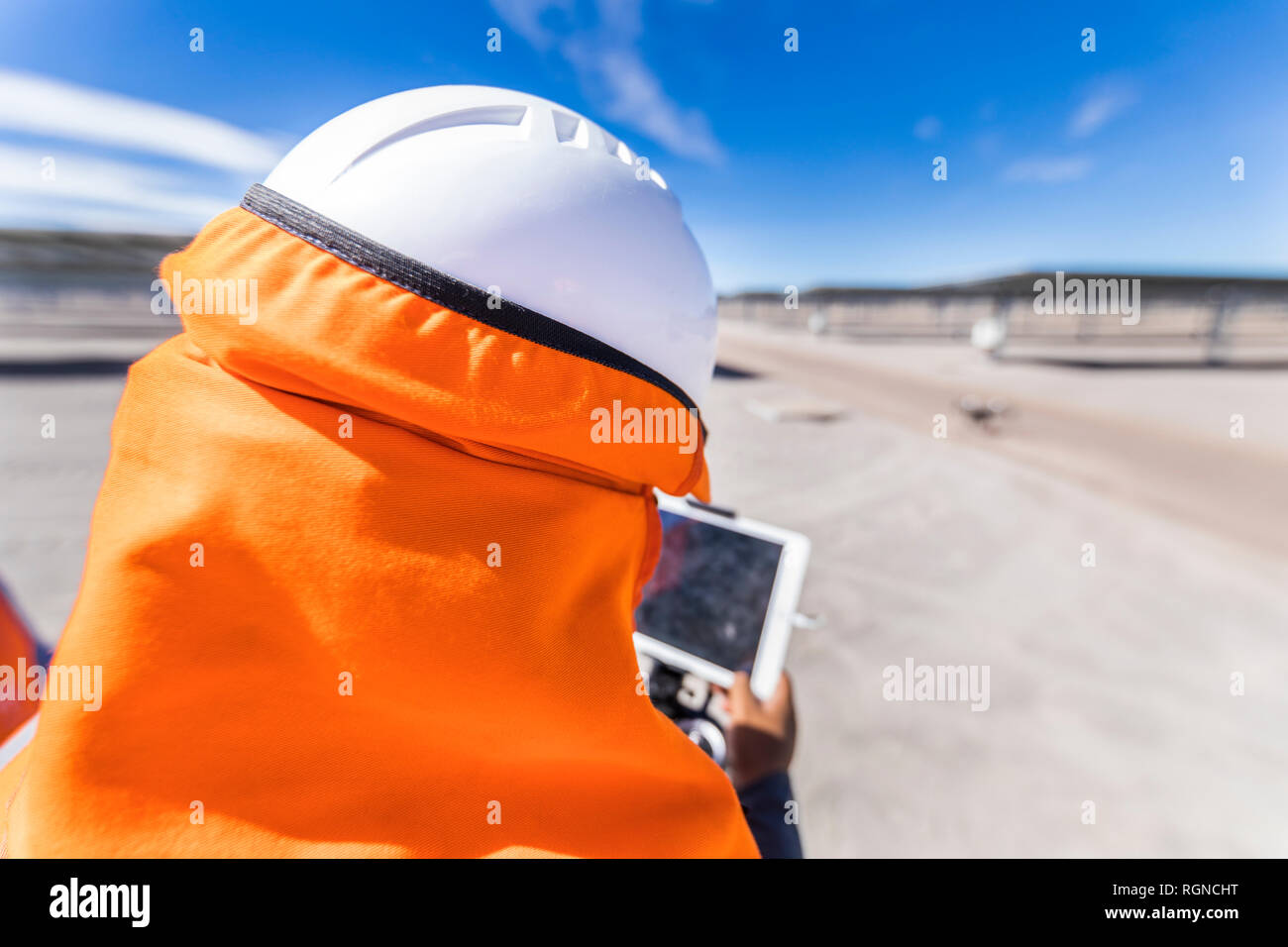 Drone inspections Solar Energy and High Voltage Lines. Drone operator working with remote control monitoring the screen during Solar Energy inspection Stock Photo