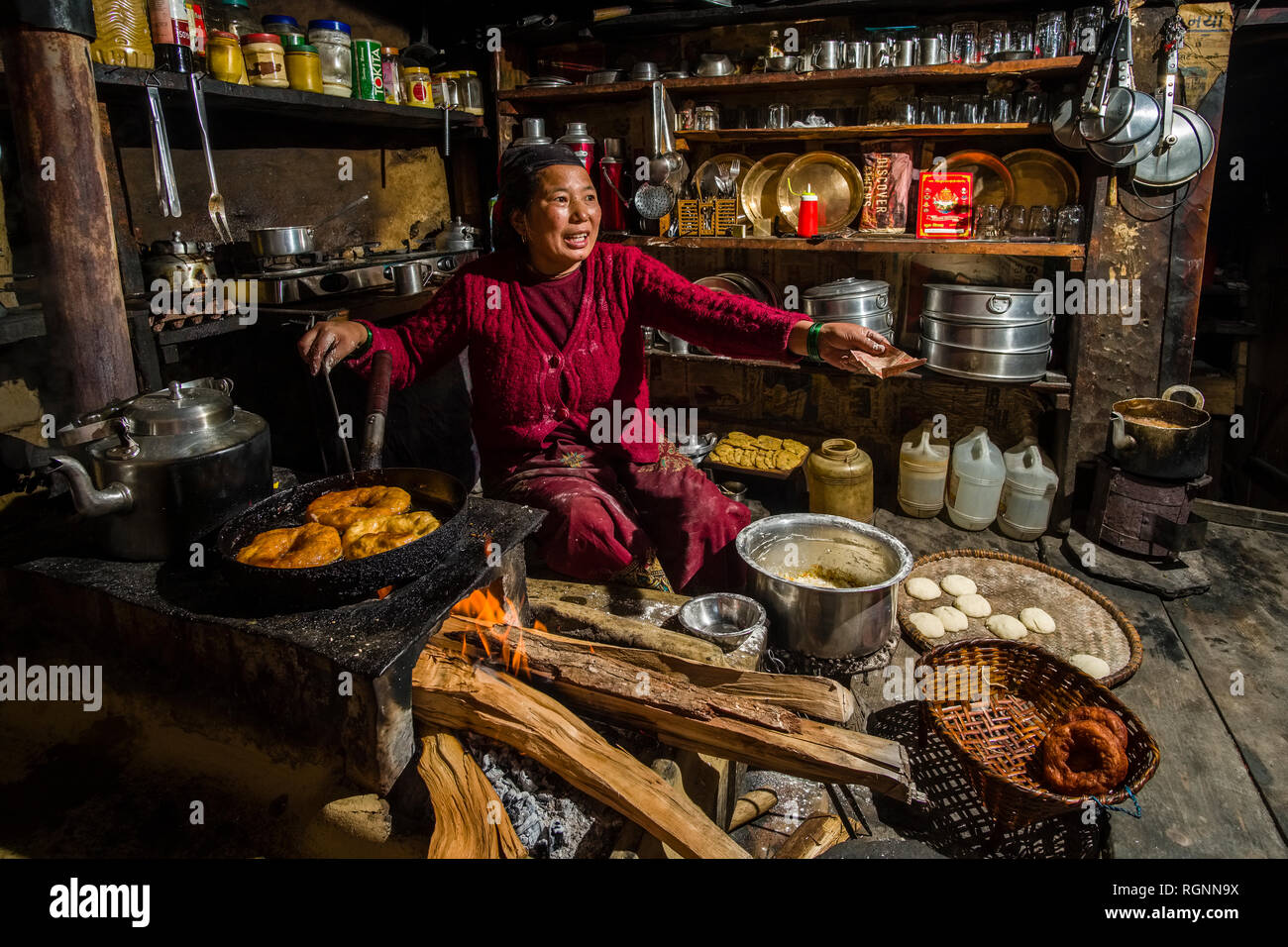 A local woman working in a traditional kitchen, preparing Doughnuts Stock Photo