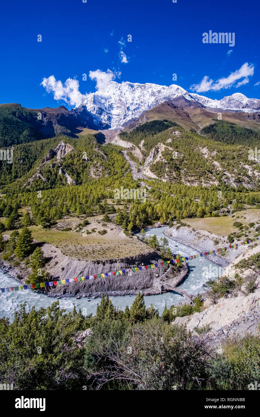 View across the Upper Marsyangdi valley, the snow covered summit of Annapurna 2 in the distance Stock Photo
