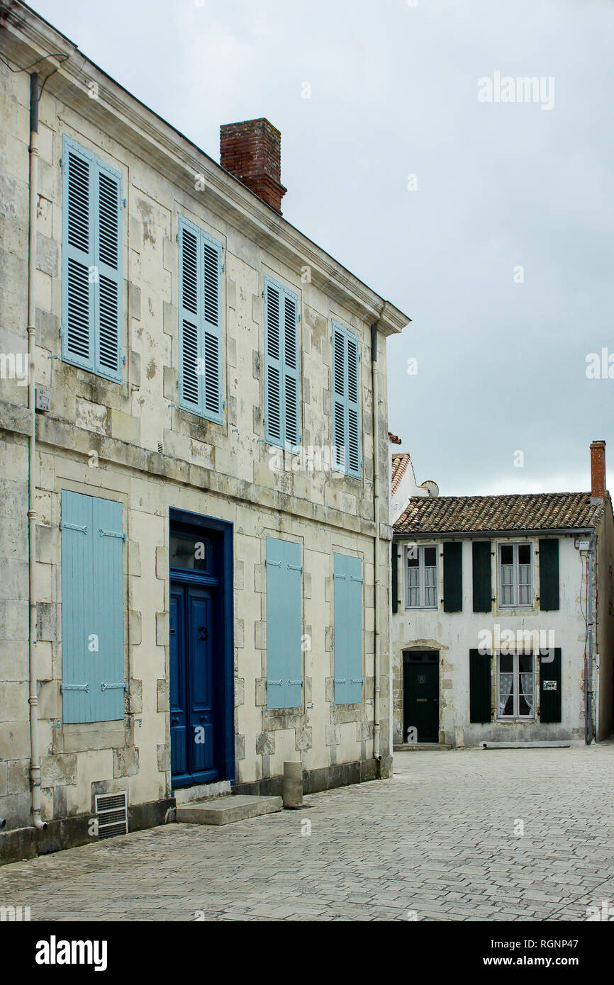 Rustic french town house with blue shutters, street scene in Ile de Re