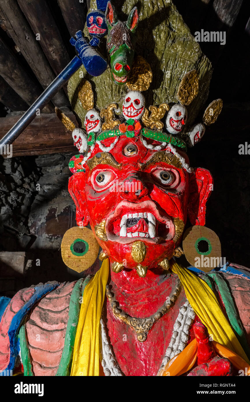 Portrait of a big red painted buddhist statue inside Braga Gompa, the local monastery Stock Photo