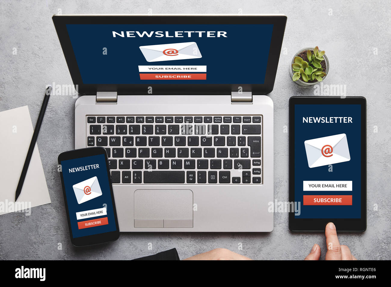 Subscribe newsletter concept on laptop, tablet and smartphone screen over gray table. All screen content is designed by me. Flat lay Stock Photo
