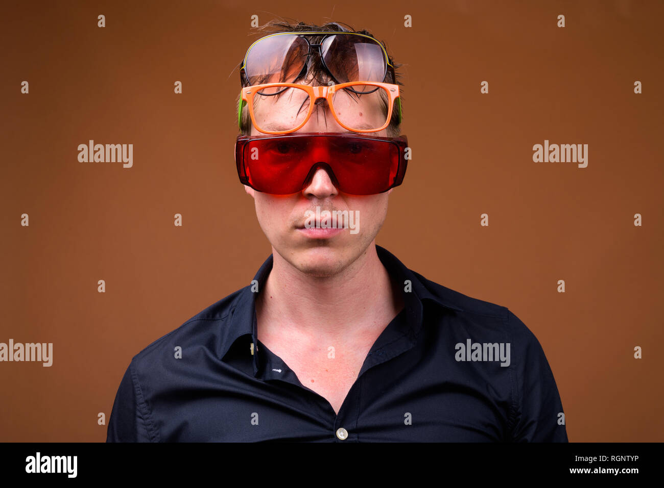 Young sad man in wet clothes wearing many sunglasses Stock Photo