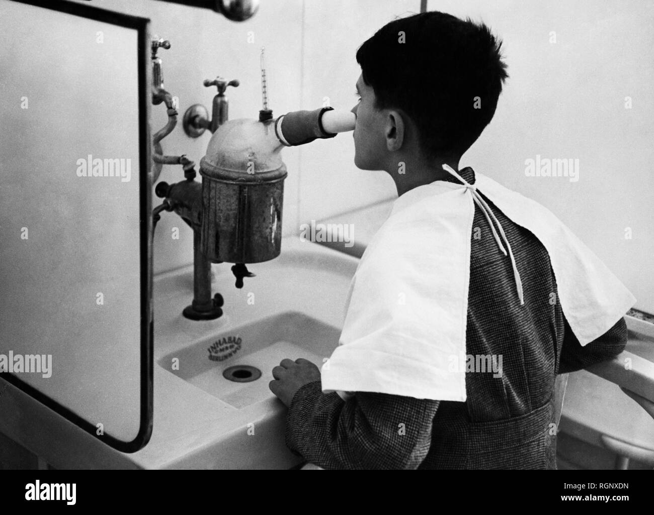 italy, abano terme, boy subjected to inhalatory treatments, 1940 Stock Photo