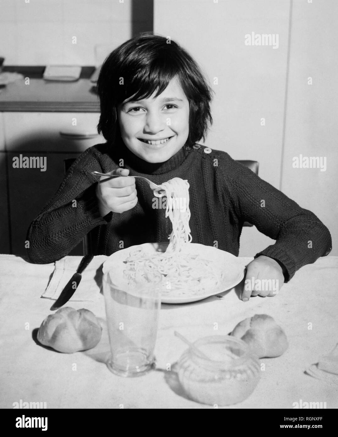 little boy eating spaghetti, 1962 Stock Photo