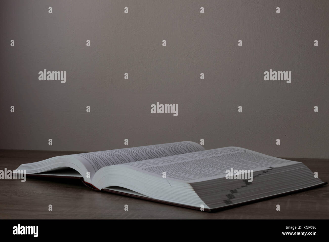 One big book opened on the brown desk Stock Photo