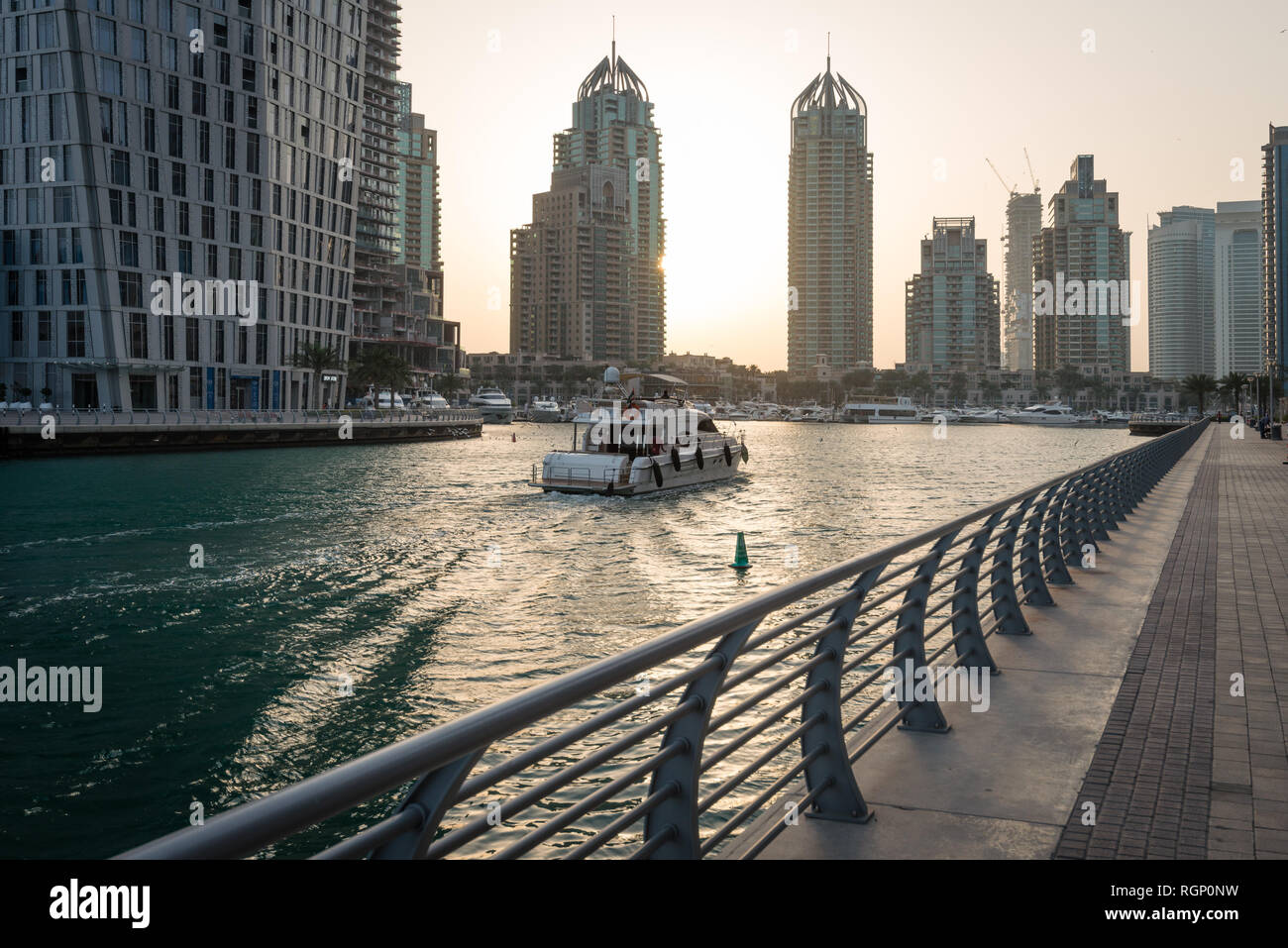 DUBAI, UAE - February 14, 2018: Boat entering Dubai Marina early in a morning. Dubai Marina is a district in the heart of what has become known as new Stock Photo