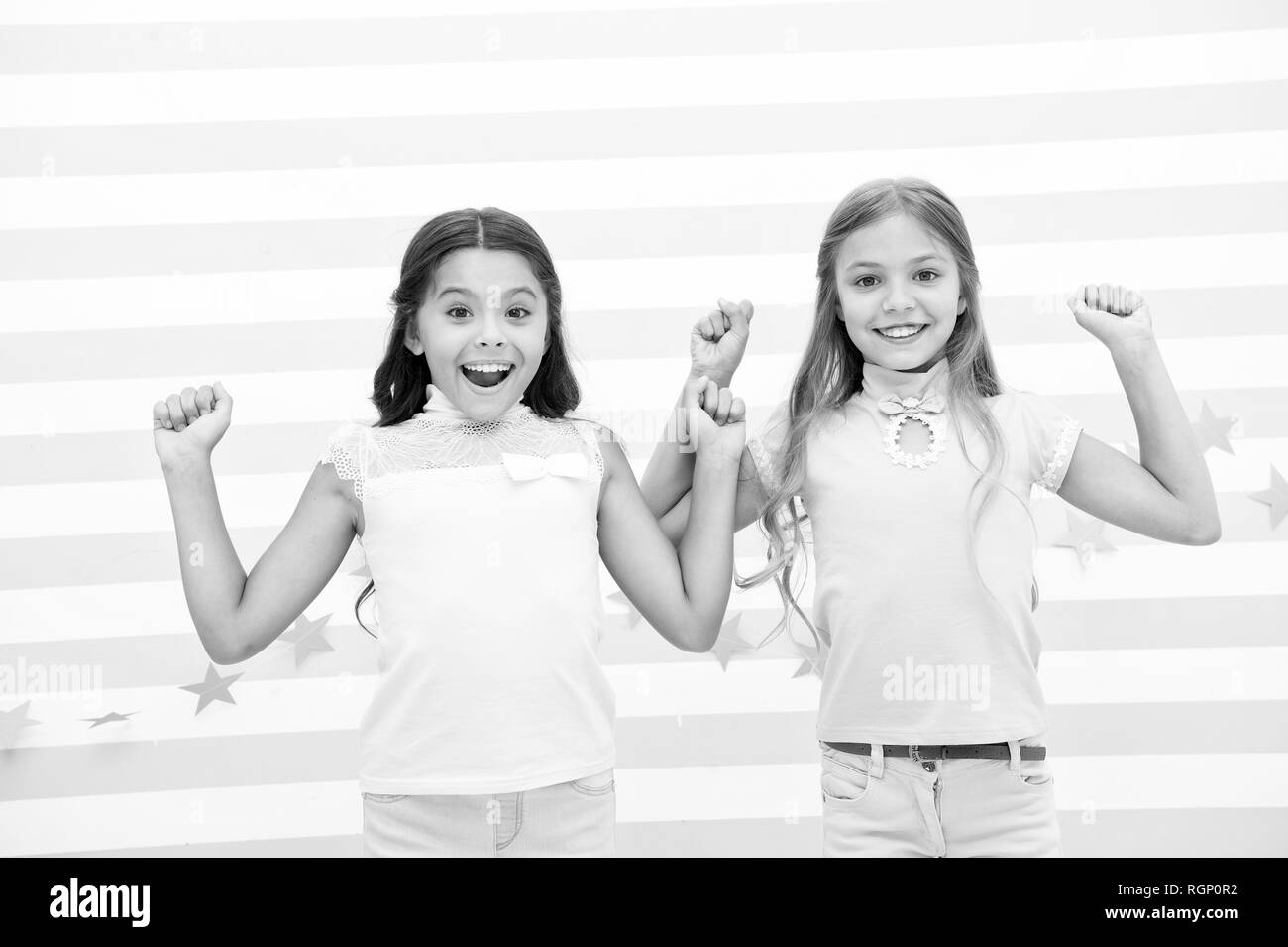 Thrilled moments together. Kids schoolgirls preteens happy together. Girls smiling happy faces excited expression stand striped background. Girls children best friends thrilled about surprising news. Stock Photo