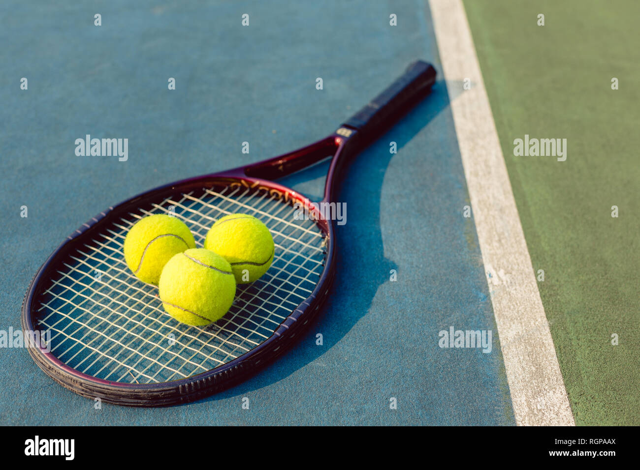 High-angle close-up of three tennis balls on a professional racket Stock Photo