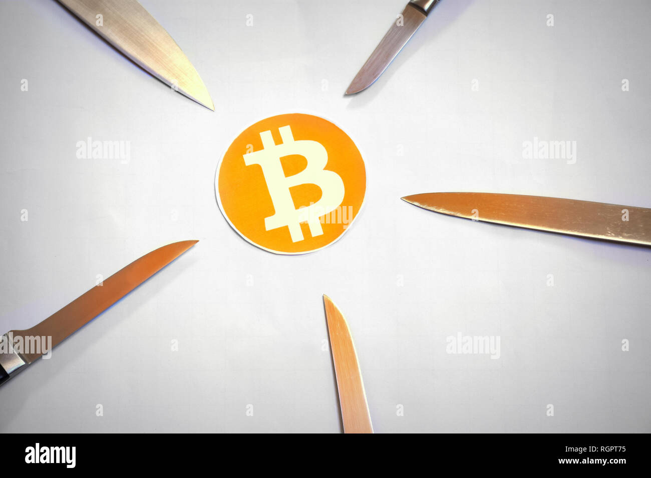 Bitcoin surrounded by five attacking knifes Stock Photo