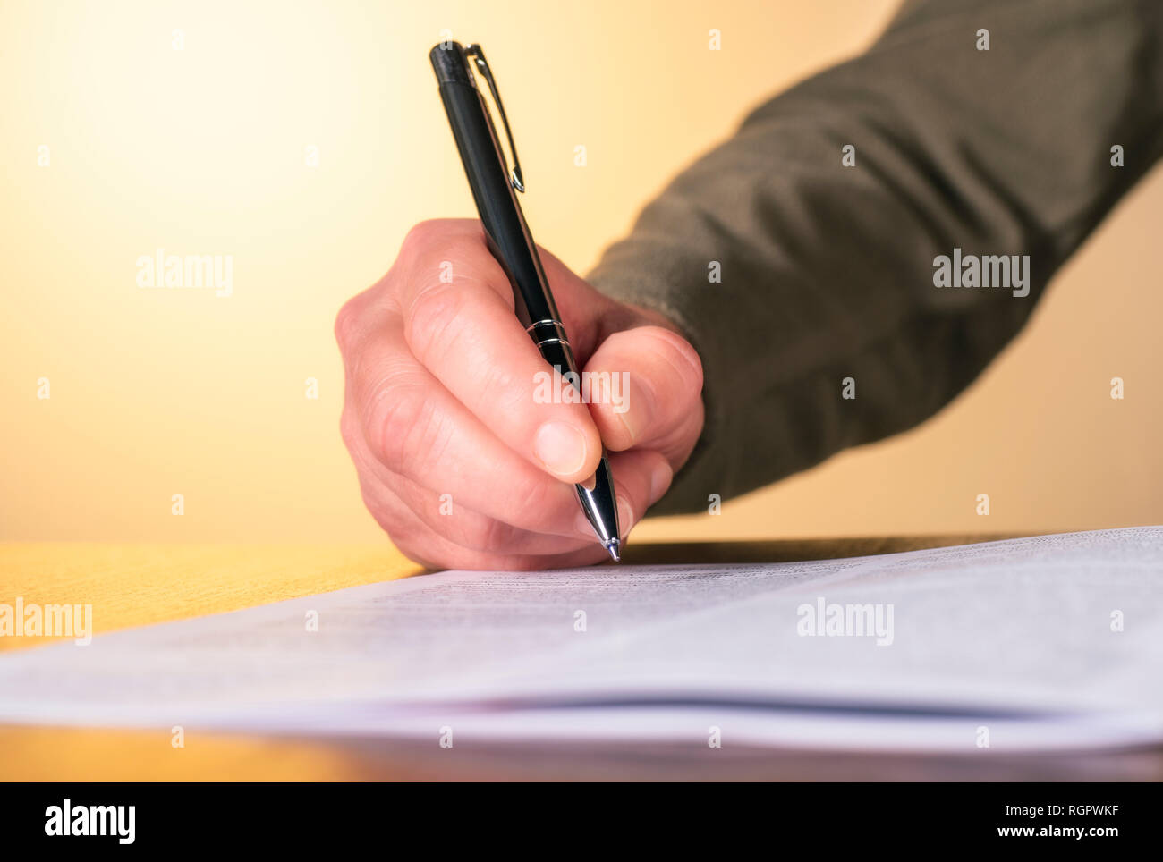 Hand of a man with pen while inspecting a document Stock Photo