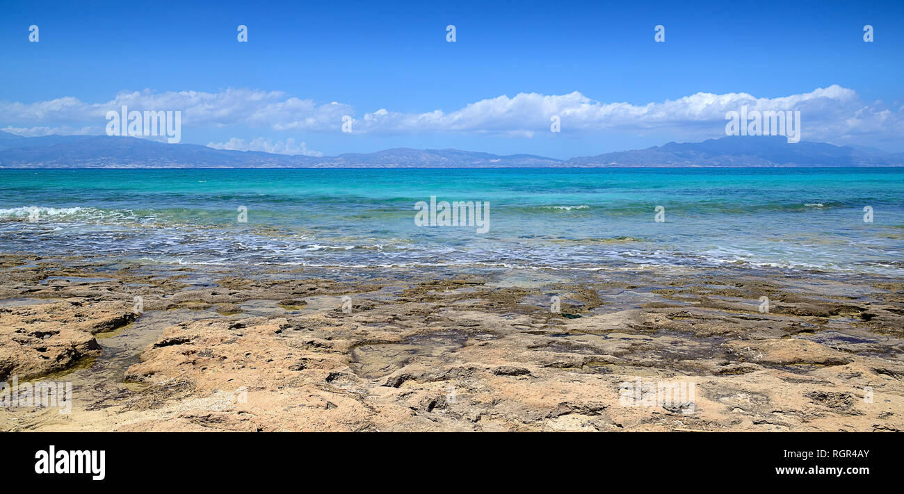sandy-stony coast, blue sea, sunny day, mountains in the distance in Dimka and clouds Stock Photo